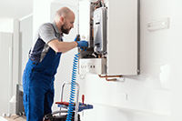 Professional servicing a boiler in a home