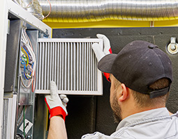 Freehold duct service technician showing homeowner clean parts of their HVAC system